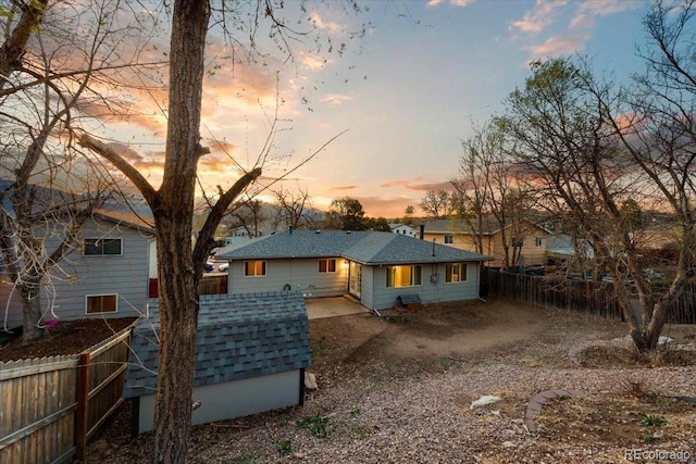 2121 Carmel Dr, Colorado Springs, CO 80910 - back of house at dusk featuring fence and roof with shingles
