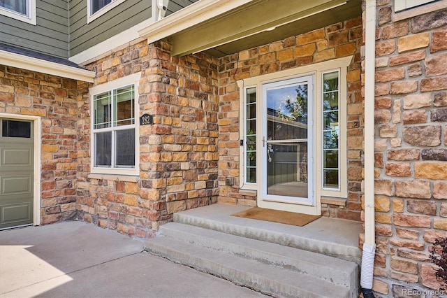 view of exterior entry with brick siding and stone siding
