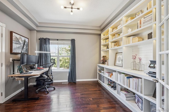 office featuring a raised ceiling, baseboards, an inviting chandelier, and hardwood / wood-style flooring