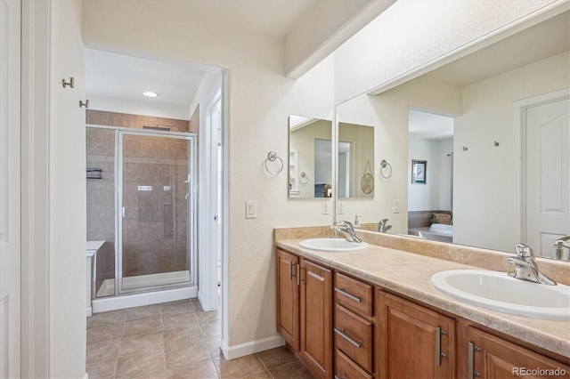 bathroom featuring double vanity, a sink, tile patterned flooring, and a stall shower