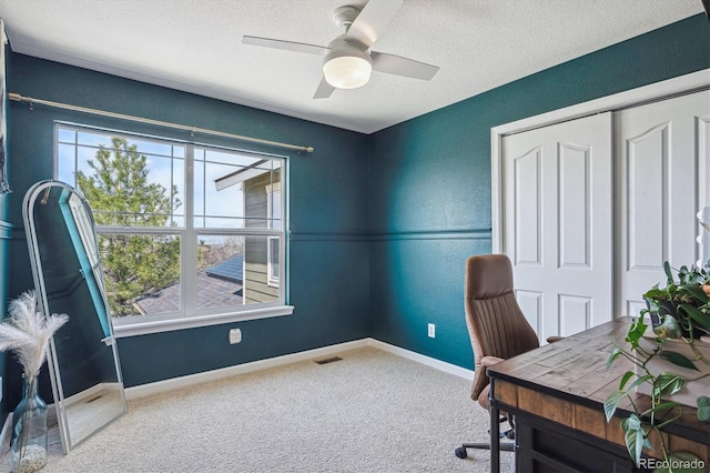 carpeted office featuring plenty of natural light, a textured ceiling, baseboards, and visible vents