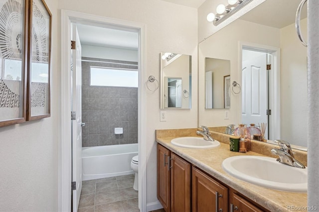 bathroom with a sink, tile patterned flooring, toilet, and double vanity