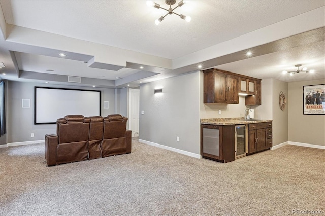 home theater with beverage cooler, a textured ceiling, and light carpet