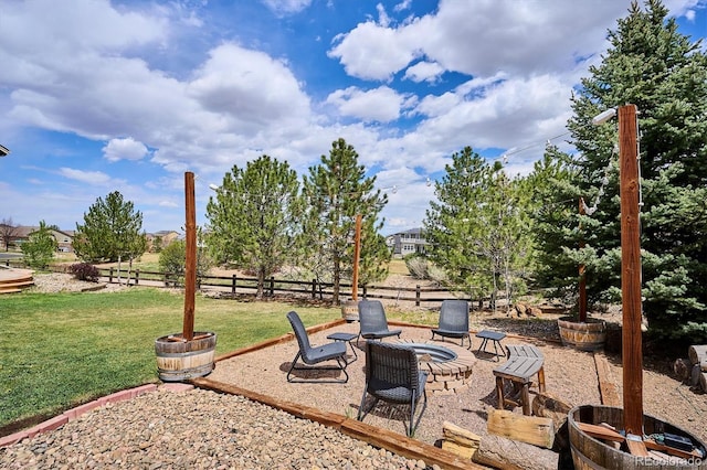 view of yard featuring fence, a fire pit, and a patio area