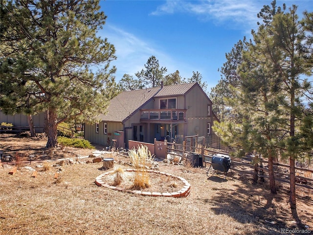 back of property featuring a balcony and a tile roof