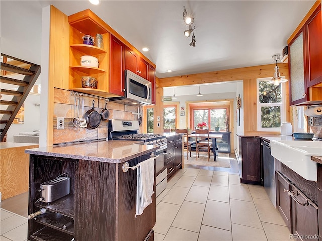 kitchen with pendant lighting, open shelves, tasteful backsplash, appliances with stainless steel finishes, and light tile patterned floors