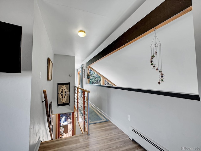 staircase featuring vaulted ceiling with beams, wood finished floors, and a baseboard radiator