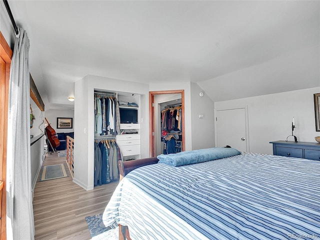 bedroom with lofted ceiling, a closet, and light wood finished floors