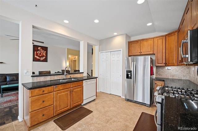 6615 Annanhill Pl, Colorado Springs, CO 80922 - kitchen with stainless steel appliances, brown cabinetry, dark stone countertops, decorative backsplash, and recessed lighting