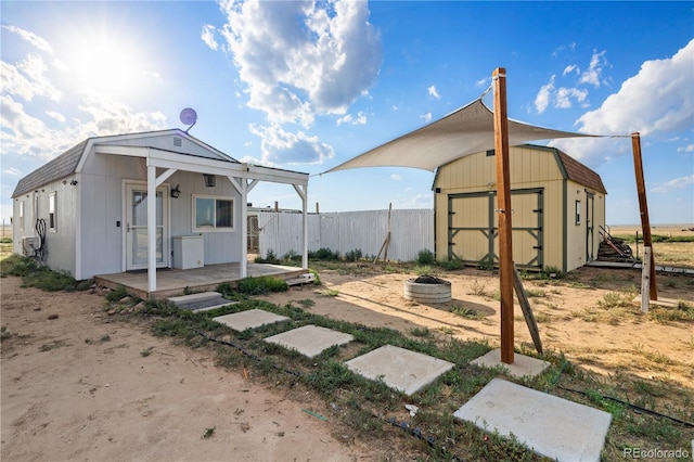 view of yard featuring a fire pit, a storage shed, fence, and an outbuilding