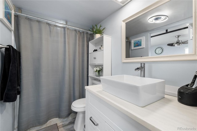 bathroom with a shower with shower curtain, vanity, toilet, and a ceiling fan