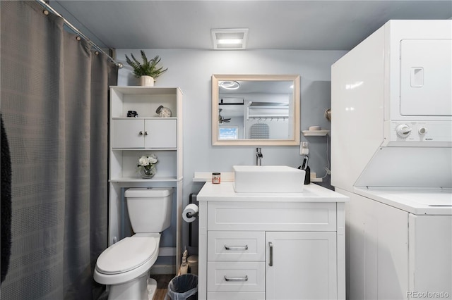 full bathroom with visible vents, toilet, a shower with curtain, stacked washer / drying machine, and vanity