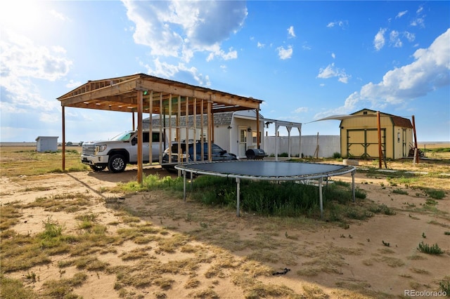 view of yard with a carport, an outbuilding, and a shed