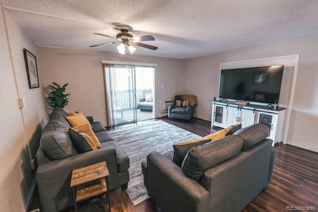 living area with a textured ceiling, dark wood finished floors, and a ceiling fan