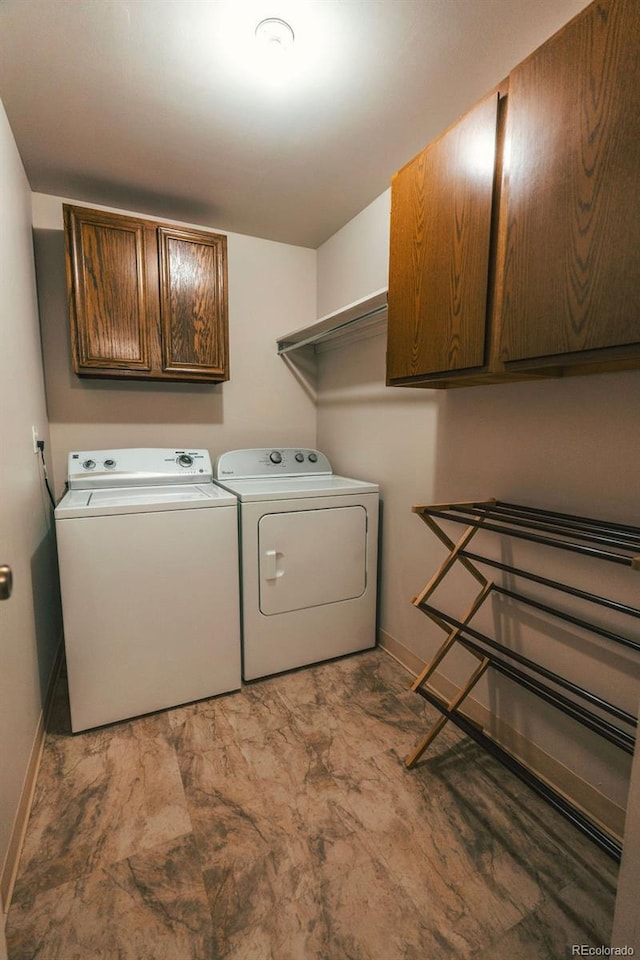 laundry area featuring cabinet space, baseboards, and independent washer and dryer