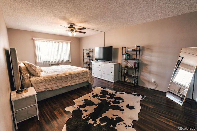 bedroom with a textured ceiling, multiple windows, and dark wood-type flooring