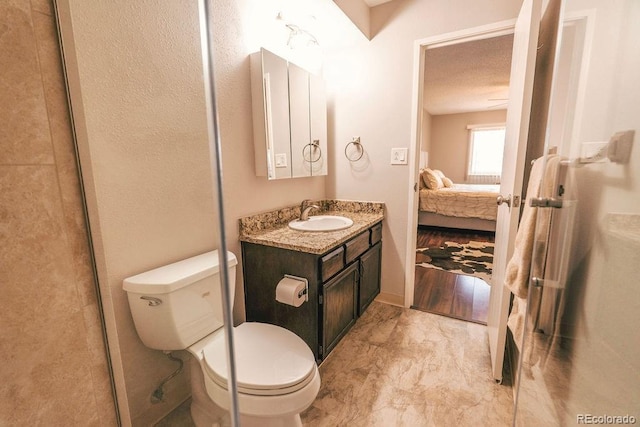 ensuite bathroom with marble finish floor, vanity, ensuite bath, and toilet