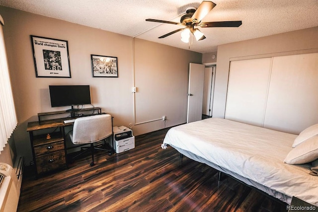 bedroom featuring a textured ceiling, dark wood-type flooring, a closet, and a ceiling fan