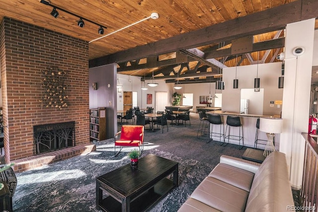 carpeted living room with wooden ceiling, a fireplace, and beam ceiling