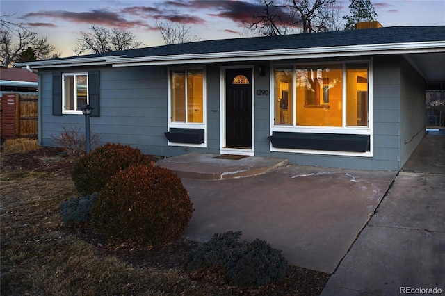 view of front of house with a shingled roof and fence