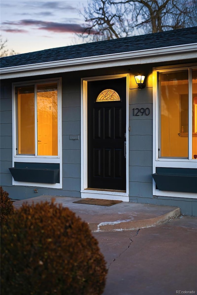 property entrance with roof with shingles