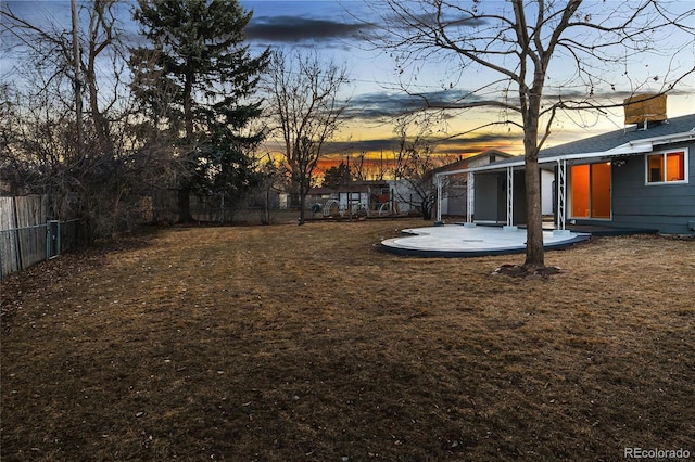 yard at dusk featuring a patio area and a fenced backyard