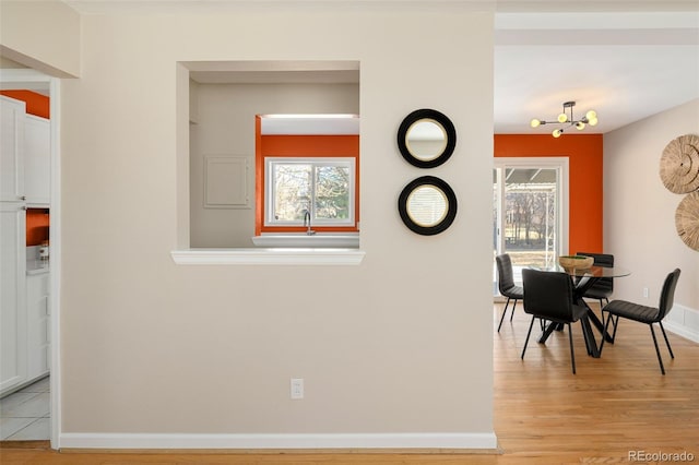 dining room featuring light wood-style flooring and baseboards