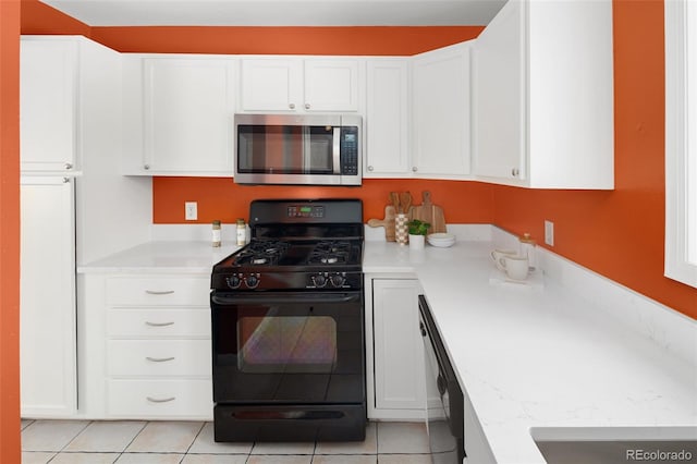 kitchen with white cabinets, stainless steel microwave, and black gas stove