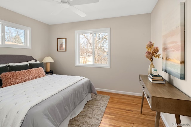 bedroom featuring light wood-style floors, baseboards, and a ceiling fan