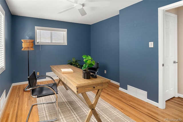 home office with ceiling fan, wood finished floors, visible vents, and baseboards