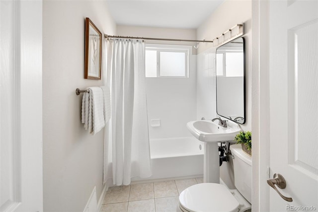 bathroom with shower / tub combo, a sink, toilet, and tile patterned floors