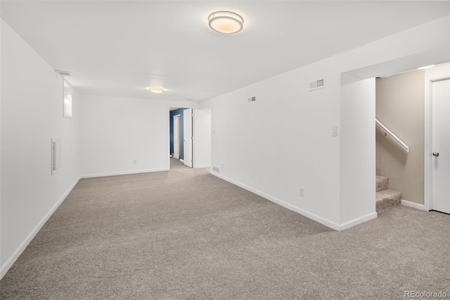 carpeted empty room featuring baseboards, stairs, and visible vents