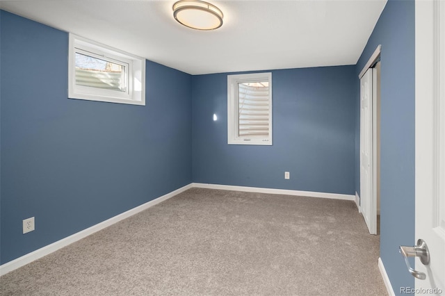 unfurnished bedroom with a closet, carpet flooring, and baseboards