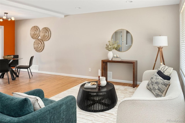 living area featuring recessed lighting, wood finished floors, baseboards, beamed ceiling, and an inviting chandelier