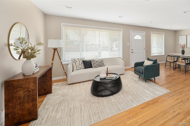 living area with light wood-type flooring, baseboards, and recessed lighting