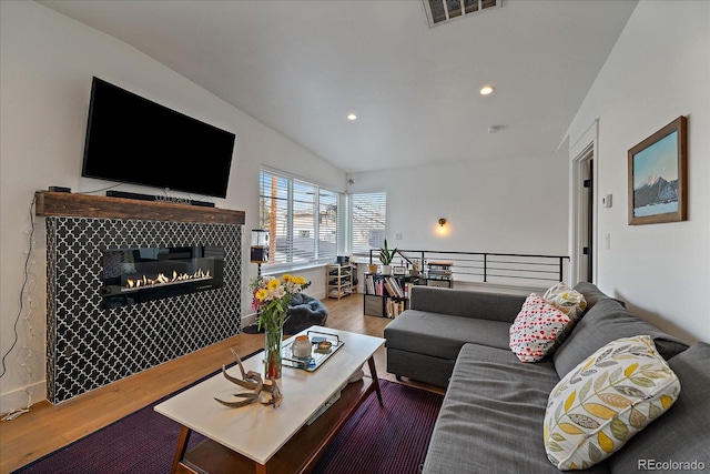 living room with recessed lighting, a tile fireplace, wood finished floors, and visible vents