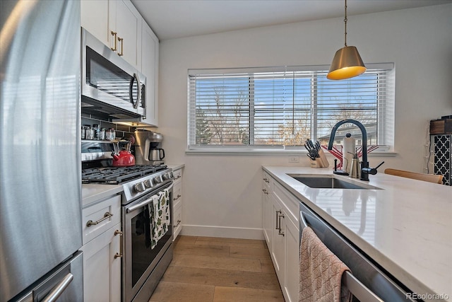 kitchen with plenty of natural light, light wood-style flooring, stainless steel appliances, and a sink