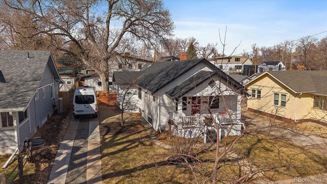 view of front of house featuring concrete driveway, a porch, a residential view, and a shingled roof