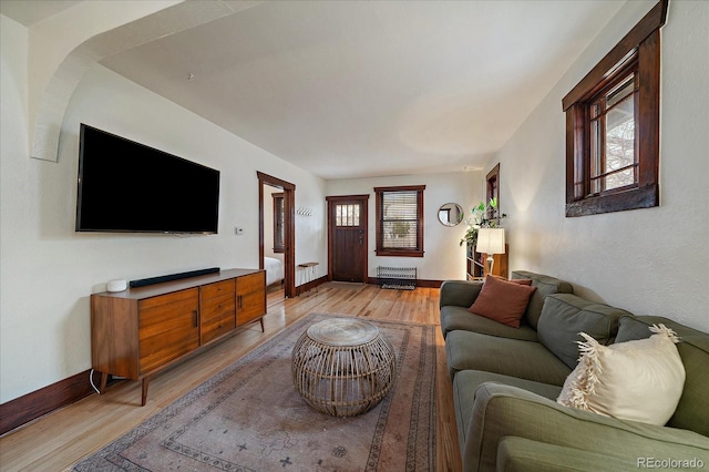 living area with light wood-style flooring and baseboards