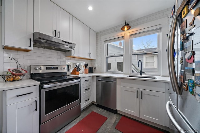 kitchen with a sink, stainless steel appliances, light countertops, backsplash, and under cabinet range hood