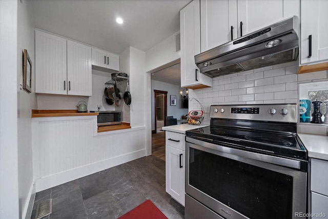 kitchen with white cabinets, stainless steel appliances, light countertops, and under cabinet range hood