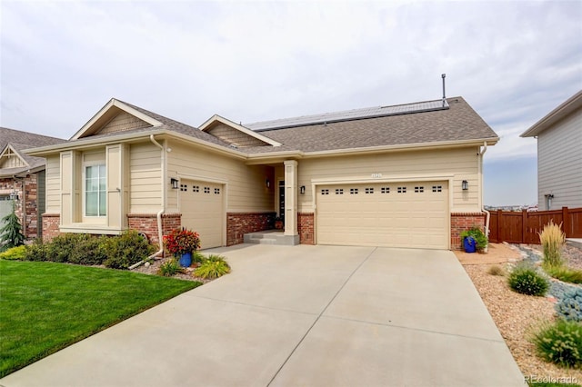 view of front of home featuring brick siding, an attached garage, and solar panels