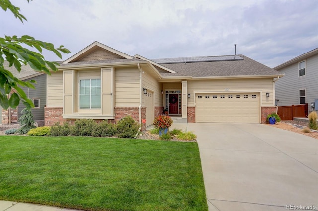 view of front of home featuring solar panels, driveway, brick siding, and an attached garage