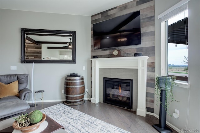 living room with a fireplace, baseboards, and wood finished floors