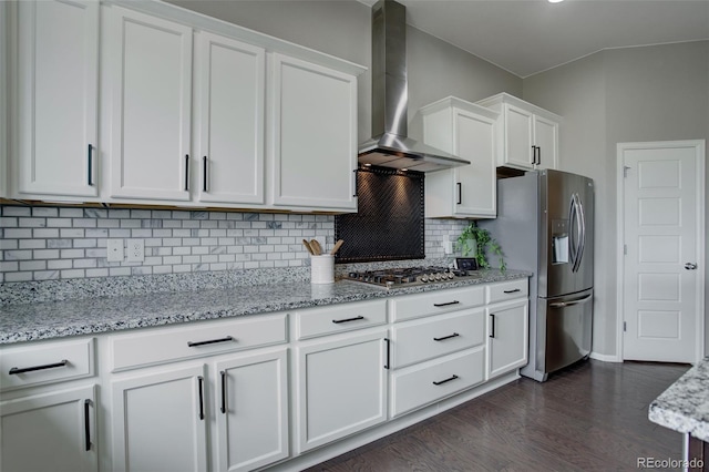 kitchen with white cabinets, light stone countertops, wall chimney exhaust hood, and stainless steel appliances