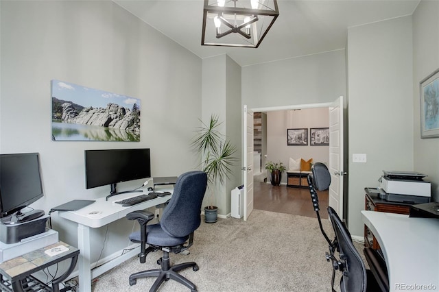 carpeted office space featuring a chandelier and french doors