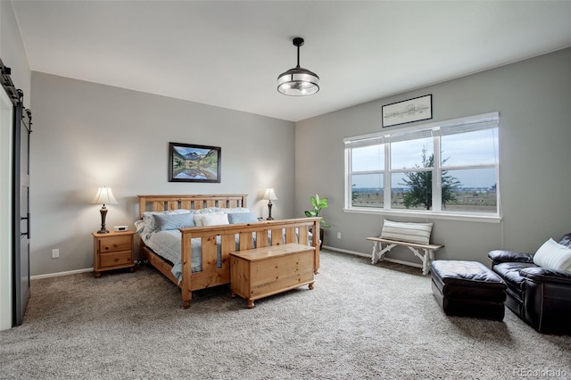 carpeted bedroom with a barn door and baseboards