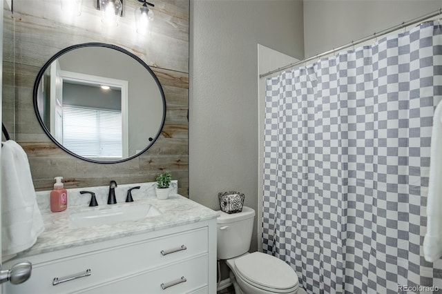 bathroom with a shower with curtain, a textured wall, vanity, and toilet