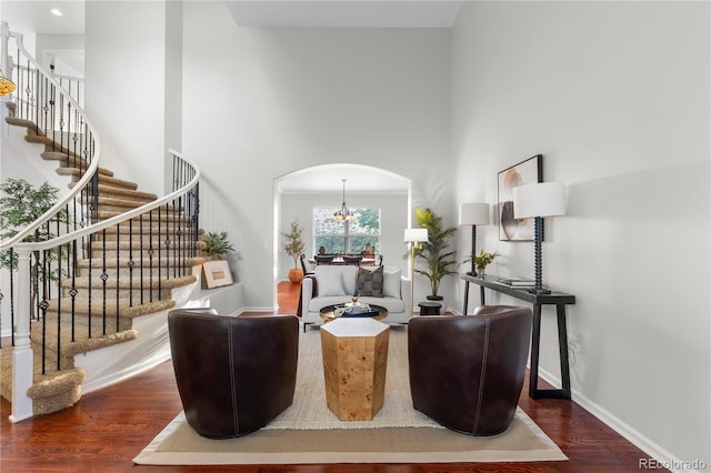 9453 Lark Sparrow Dr, Highlands Ranch, CO 80126 - living area featuring arched walkways, wood finished floors, a towering ceiling, stairs, and baseboards