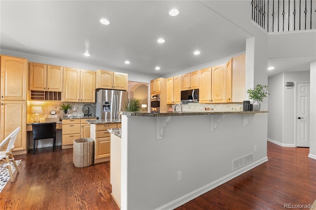 9453 Lark Sparrow Dr, Highlands Ranch, CO 80126 - kitchen with appliances with stainless steel finishes, light brown cabinetry, dark wood-type flooring, and recessed lighting
